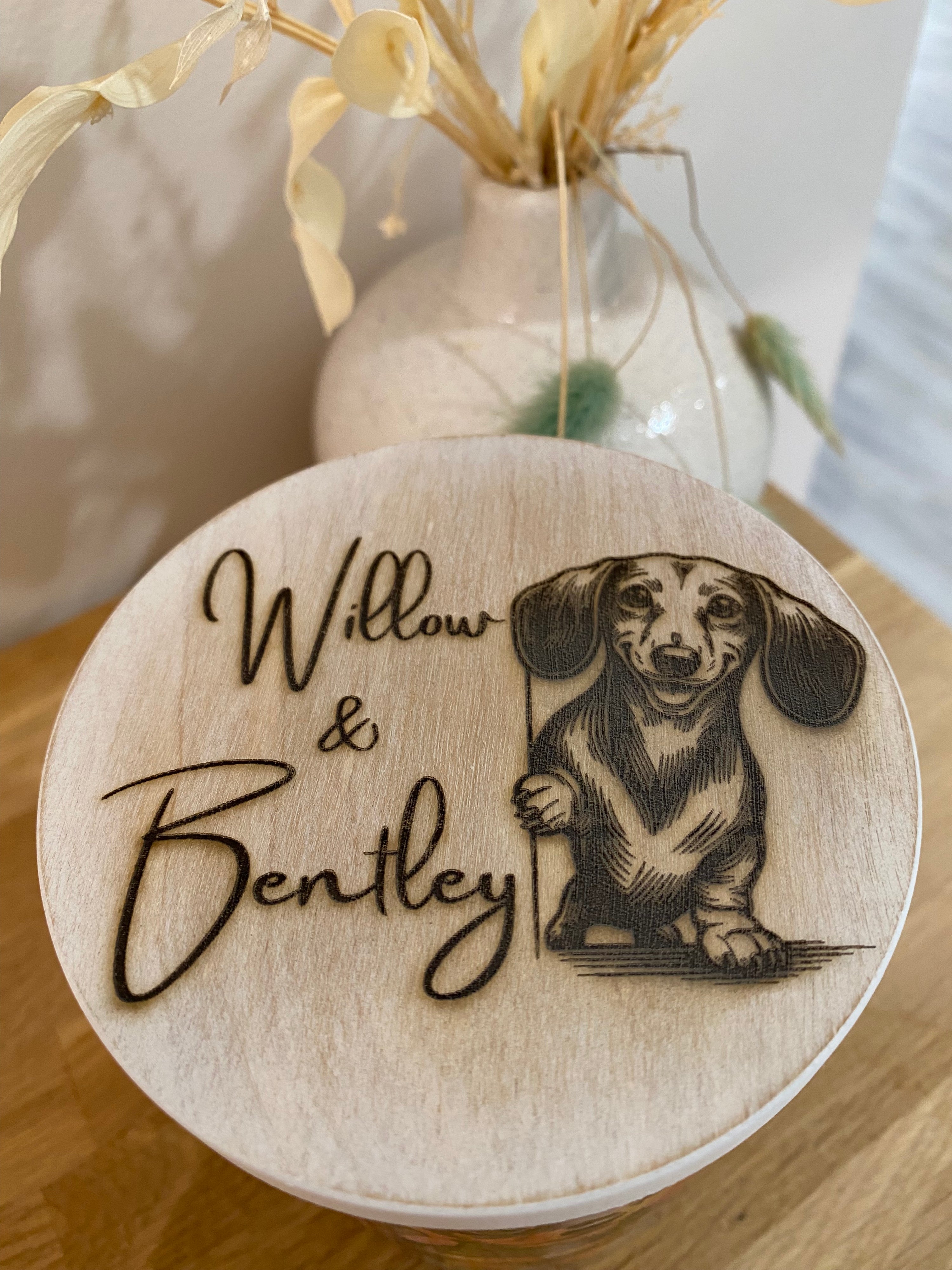 Pet-themed wooden candle lid featuring a dachshund illustration and the names &