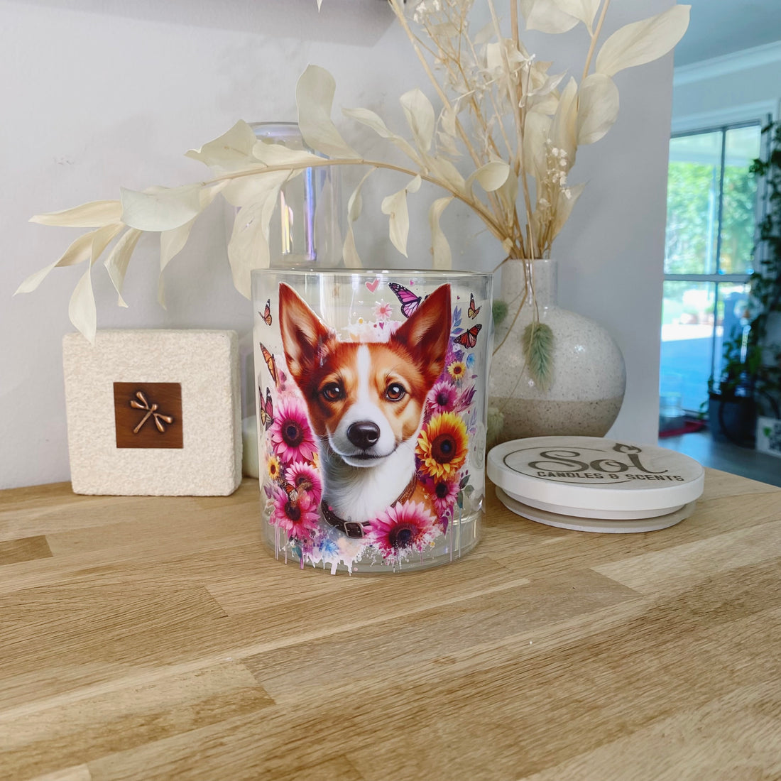 Decorative candle with a dog design on a wooden surface