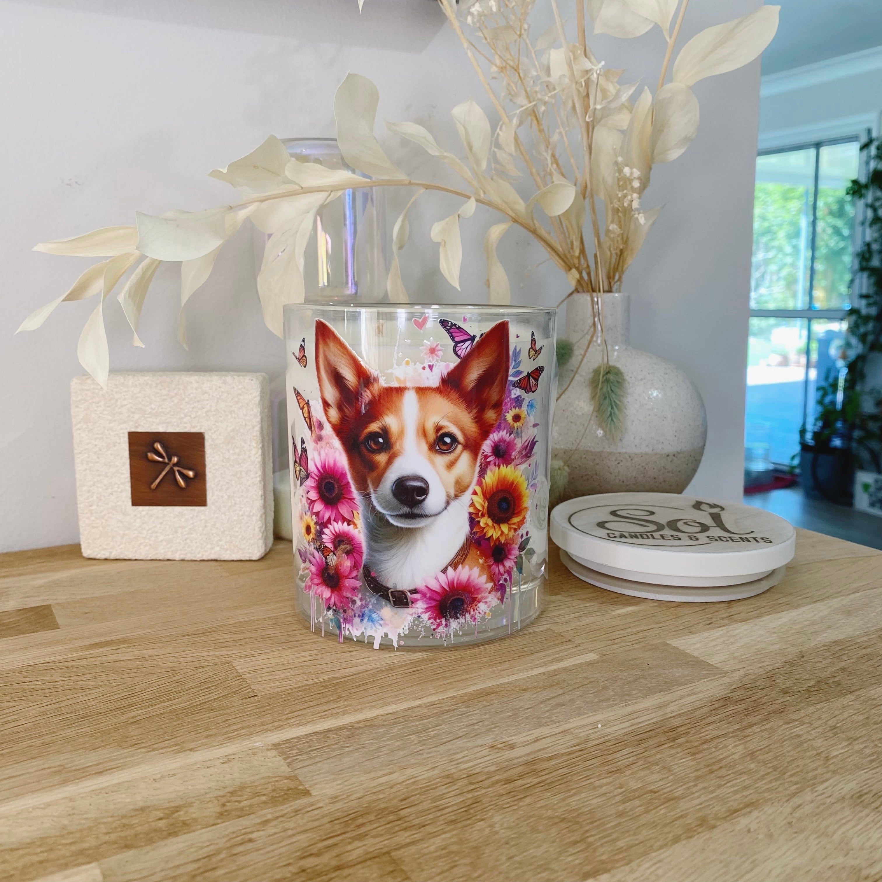 Decorative candle with a dog design on a wooden surface