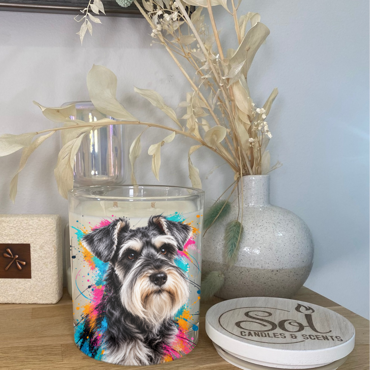 A portrait of a Schnauzer on a colourful background placed onto a Soy Candle
