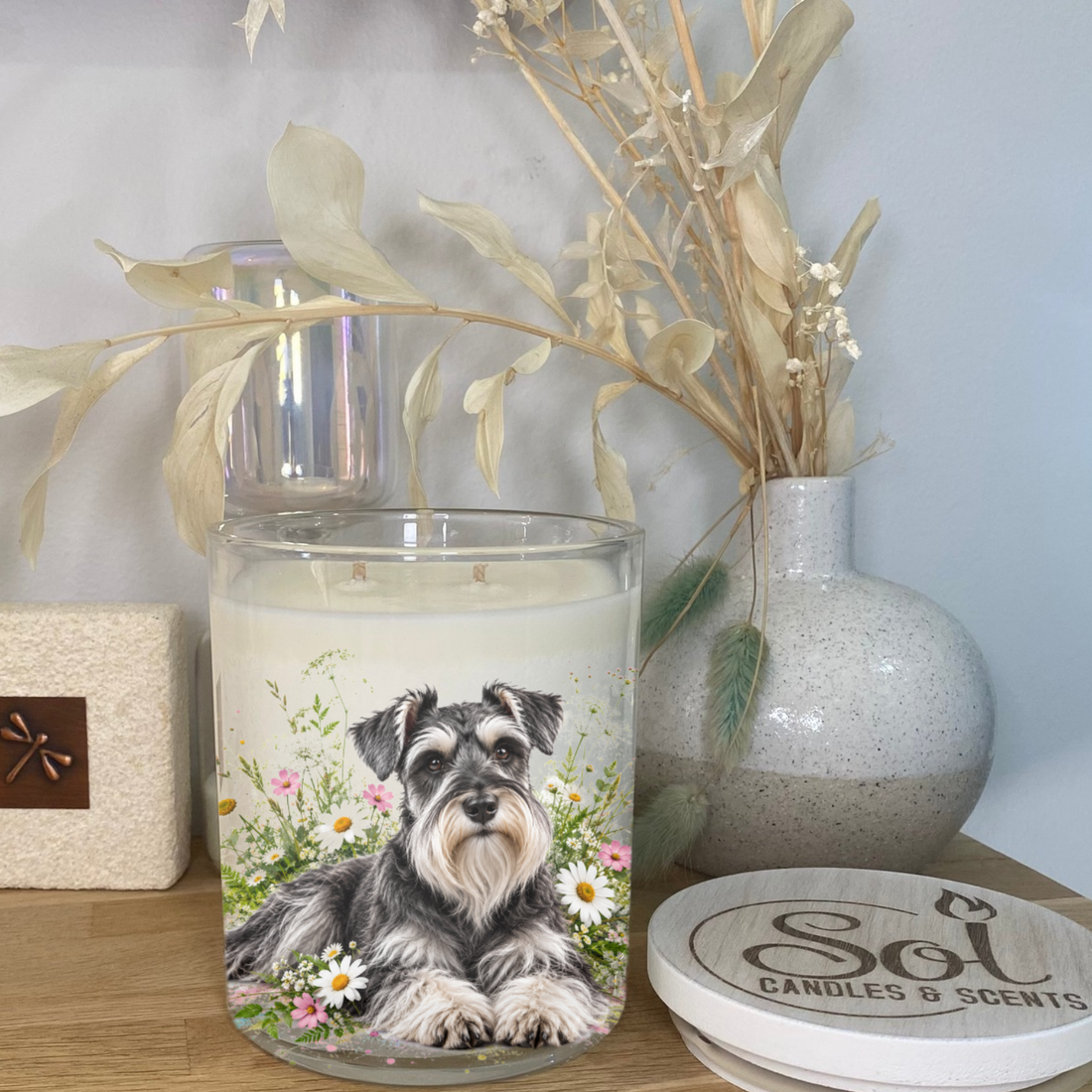 A Schnauzer Dog laying down in pastel flowers. Placed onto a Soy Candle. Sol Candles &amp; Scents